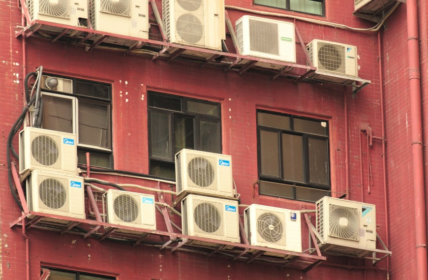 Häuserfassade in Hong Kong mit zahlreich angebrachten Klimaanlagen.