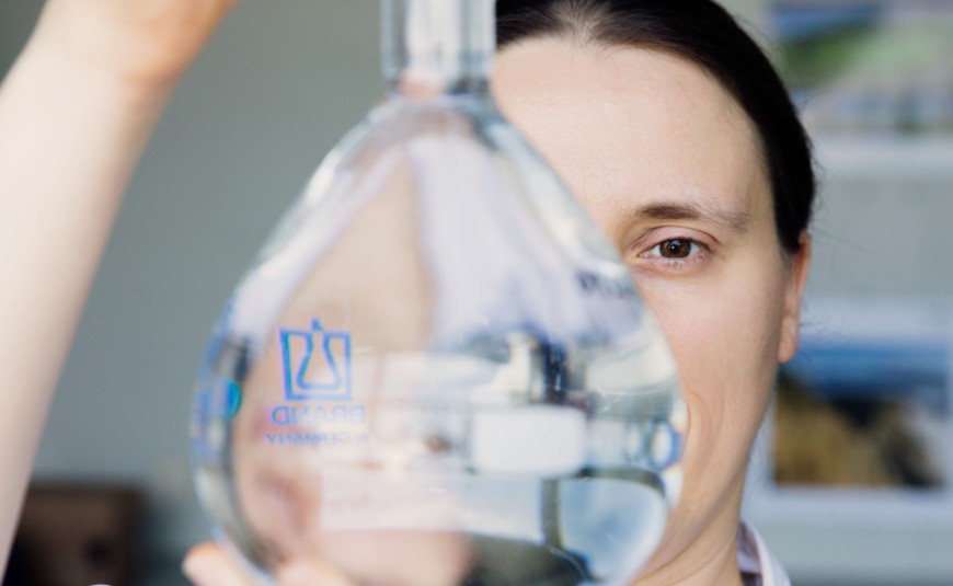 Professorin Dr. Susanne Lackner schaut durch ein Kolbenglas.