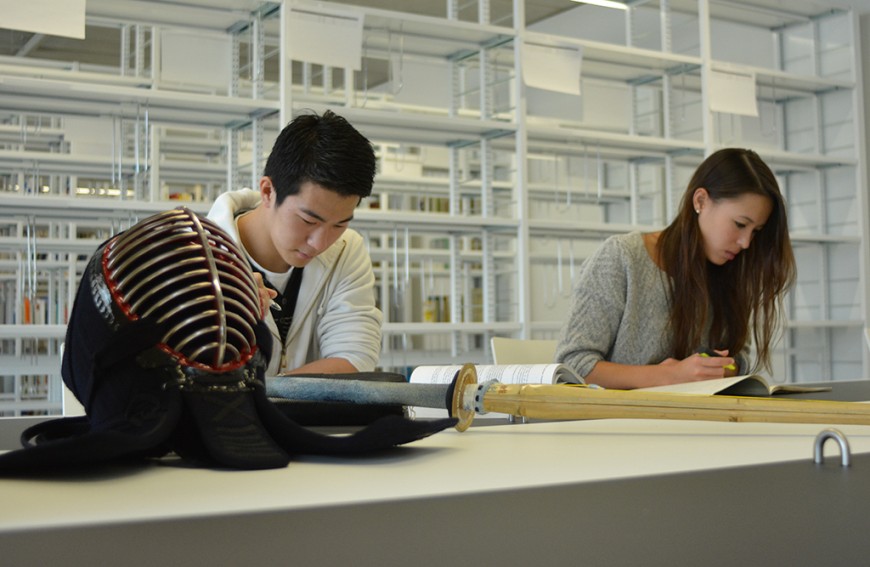 Im Vordergrund eine Kendomaske, dahinter sitzen Hiroyuki Ohno und Lissa Meinberg an einem Tisch. Bild: Jannes Lüdtke