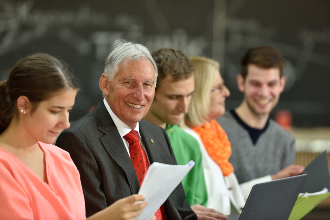 Elder Stateman sitting together with young students