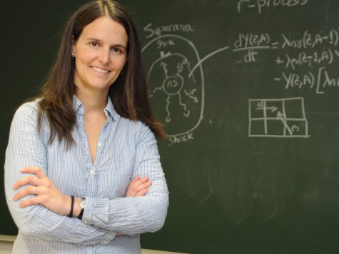 Die Physikerin Almudena Arcones schaut vor einer Schultafel lächelnd in die Kamera. Bild: Otto Gabriele / GSI