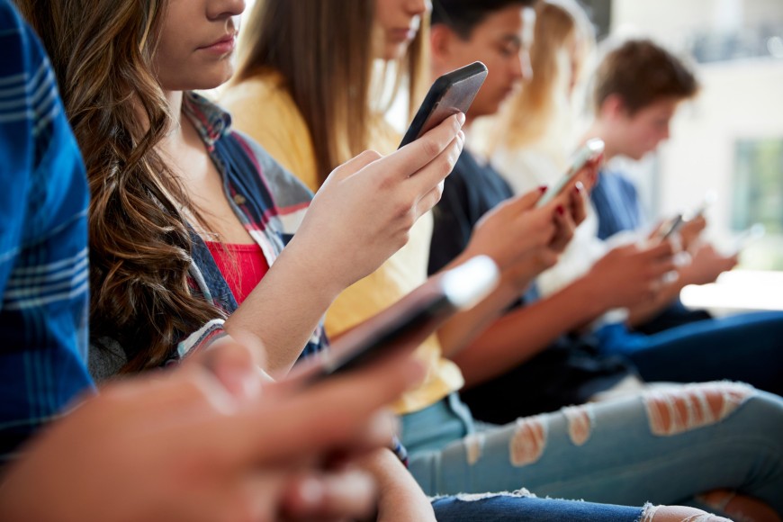 Close Up Of A Line Of High School Students Using Mobile Phones by Monkey Business on Adobe Stock