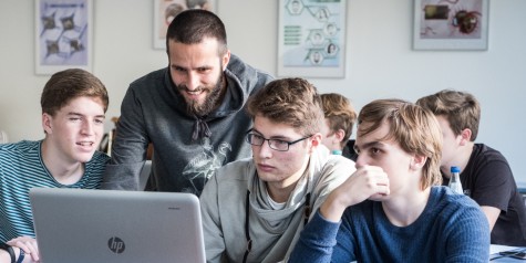 Während des Studienstarts gibt es viele Möglichkeiten besondere Unterstützungsangebote in Gruppenform wahrzunehmen. Studierende helfen sich untereinander und bekommen von geschulten Studierenden erweiterte Hilfestellungen. Mehrere Studierende sitzen zusammen vor einem Laptop und arbeiten gemeinsam an einer Fragestellung. // During the start of your studies, there are many opportunities to take advantage of special support services in group form. Students help each other and receive extended assistance from trained students. Several students sit together in front of a laptop and work together on a question.